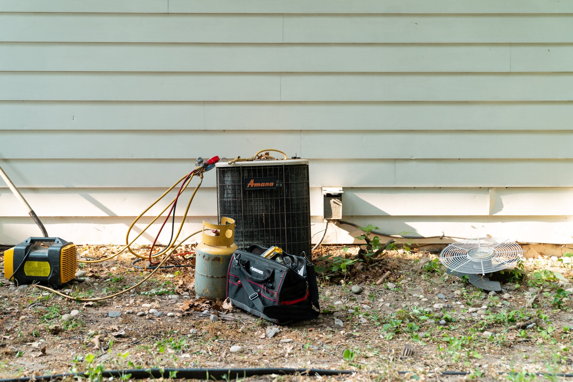An outdoor air conditioner having its AC refrigerant checked.