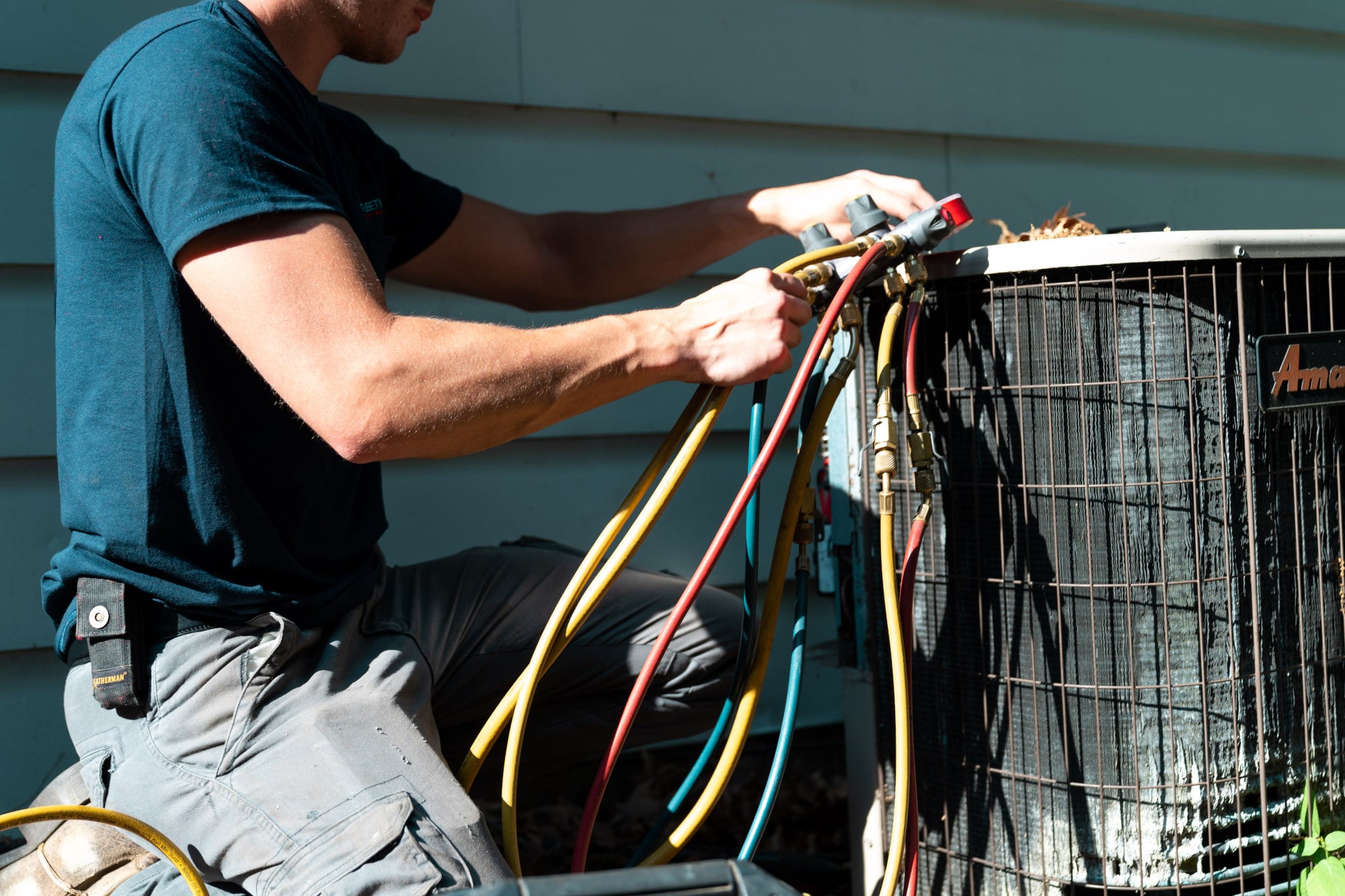 An AC technician diagnosing issues with an outdoor AC unit.