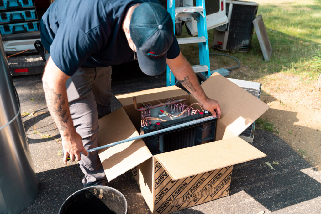 A Fleetwood's technician unboxes a brand-new AC unit.